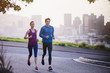 © Ryan Lees/Caia Image - Runner couple running on urban city street