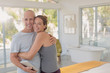 © Tom Merton/Caia Image - Portrait happy mature couple with digital tablet hugging in bedroom