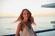 © Tom Merton/Caia Image - Portrait confident woman turning on luxury balcony with sunset ocean view
