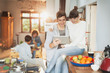 © Justin Pumfrey/Caia Image - Smiling young couple using digital tablet in kitchen