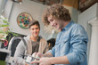© Justin Pumfrey/Caia Image - Young men roommates cooking in kitchen