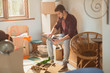 © Justin Pumfrey/Caia Image - Young man using laptop surrounded by moving boxes in apartment