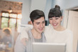 © Justin Pumfrey/Caia Image - Smiling young couple using digital tablet