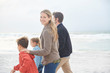 © Ryan Lees/Caia Image - Portrait smiling family walking on winter beach