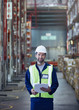 © Ryan Lees/Caia Image - Portrait smiling worker with clipboard in distribution warehouse