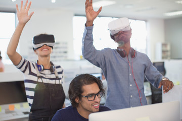 Computer programmers testing virtual reality simulators in office
