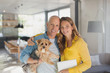 © Tom Merton/Caia Image - Portrait smiling mature couple hugging with dog in living room
