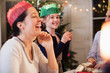 © Sam Edwards/Caia Image - Happy family in paper crowns laughing at Christmas dinner