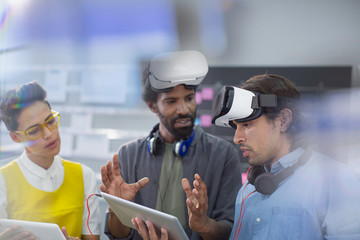 Computer programmers with digital tablet programming virtual reality simulators