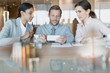 © Tom Merton/Caia Image - Business people using cell phone in conference room meeting