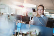 © Tom Merton/Caia Image - Businesswoman using remote control, drinking coffee in office