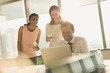 © Tom Merton/Caia Image - Business people working at laptop in sunny office