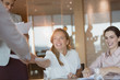 © Tom Merton/Caia Image - Smiling businesswoman handing paperwork to colleague in conference room meeting