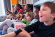 © Paul Bradbury/Caia Image - Multi-ethnic family watching movie and eating popcorn