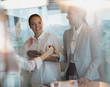 © Tom Merton/Caia Image - Businesswomen laughing, handshaking in office meeting