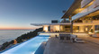 © Tom Merton/Caia Image - Illuminated modern, luxury home showcase exterior patio with lap pool and ocean view at twilight