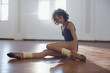 © Sam Edwards/Caia Image - Focused, strong young female dancer stretching leg in dance studio