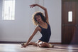 © Sam Edwards/Caia Image - Graceful young female dancer stretching in dance studio