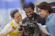 © Tom Merton/Caia Image - Smiling journalists and cameraman using digital camera