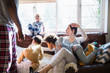 © Sam Edwards/Caia Image - Multi-ethnic young family in pajamas playing in sunny living room