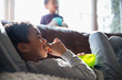 © Sam Edwards/Caia Image - Boy eating snack and watching TV on sofa