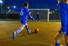 Girl Soccer Player Kicking Ball Toward Goal