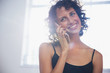 © Sam Edwards/Caia Image - Smiling young woman talking on smart phone
