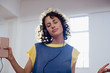 © Sam Edwards/Caia Image - Carefree young female dancer listening to music with headphones and mp3 player