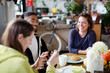 © Tom Merton/Caia Image - Young adult roommate friends enjoying breakfast at apartment kitchen table