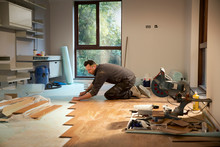Construction Worker Laying Hardwood Flooring In House