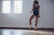 © Sam Edwards/Caia Image - Graceful young female ballet dancer stretching foot in dance studio