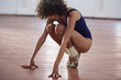 © Sam Edwards/Caia Image - Young female ballet dancer stretching in dance studio
