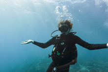 Portrait Young Woman Scuba Diving Underwater With Arms Outstretched