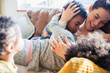 © Sam Edwards/Caia Image - Affectionate mother and children cuddling on sofa