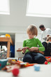 © Paul Bradbury/Caia Image - Curious boy assembling wood blocks on floor
