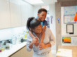 © Paul Bradbury/Caia Image - Playful mother and son piggybacking in kitchen