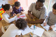 © Sam Edwards/Caia Image - Family coloring at dining table