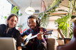 © Tom Merton/Caia Image - Young man and woman recording music, playing guitar in apartment