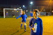 © Paul Bradbury/Caia Image - Portrait smiling girl soccer player drinking water on field at night