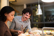 © Sam Edwards/Caia Image - Smiling couple eating dinner with chopsticks in apartment kitchen