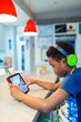 © Paul Bradbury/Caia Image - Boy with headphones and digital tablet playing video game