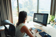 © Paul Bradbury/Caia Image - Businesswoman with headset working at computer in home office