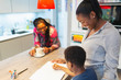 © Paul Bradbury/Caia Image - Multi-generation family coloring in kitchen