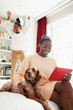 © Paul Bradbury/Caia Image - Playful boy jumping on bed behind dog and mother with digital tablet
