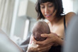 © Sam Edwards/Caia Image - Mother cradling and breastfeeding newborn baby son