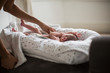 © Sam Edwards/Caia Image - Mother reaching for newborn baby son in bassinet