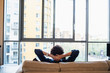 © Sam Edwards/Caia Image - Man relaxing on urban apartment sofa