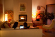 © Tom Merton/Caia Image - Couple using digital tablet on living room sofa facing fireplace