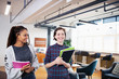 © Sam Edwards/Caia Image - Smiling businesswomen walking and talking in office