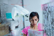 © Tom Merton/Caia Image - Female engineer with paperwork planning, programming robotic arm